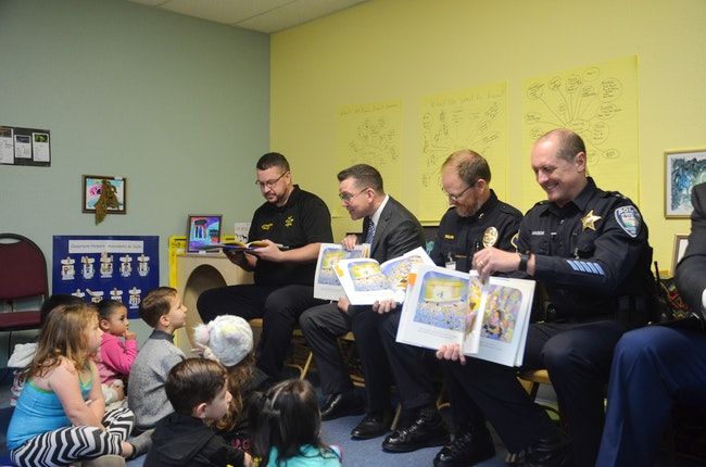 Independence Police Chief Robert Mason, Monmouth Police Chief Darrell Tallan, Polk County Sheriff Mark Garton, and Polk County District Attorney Aaron Felton read to preschool students in Oregon